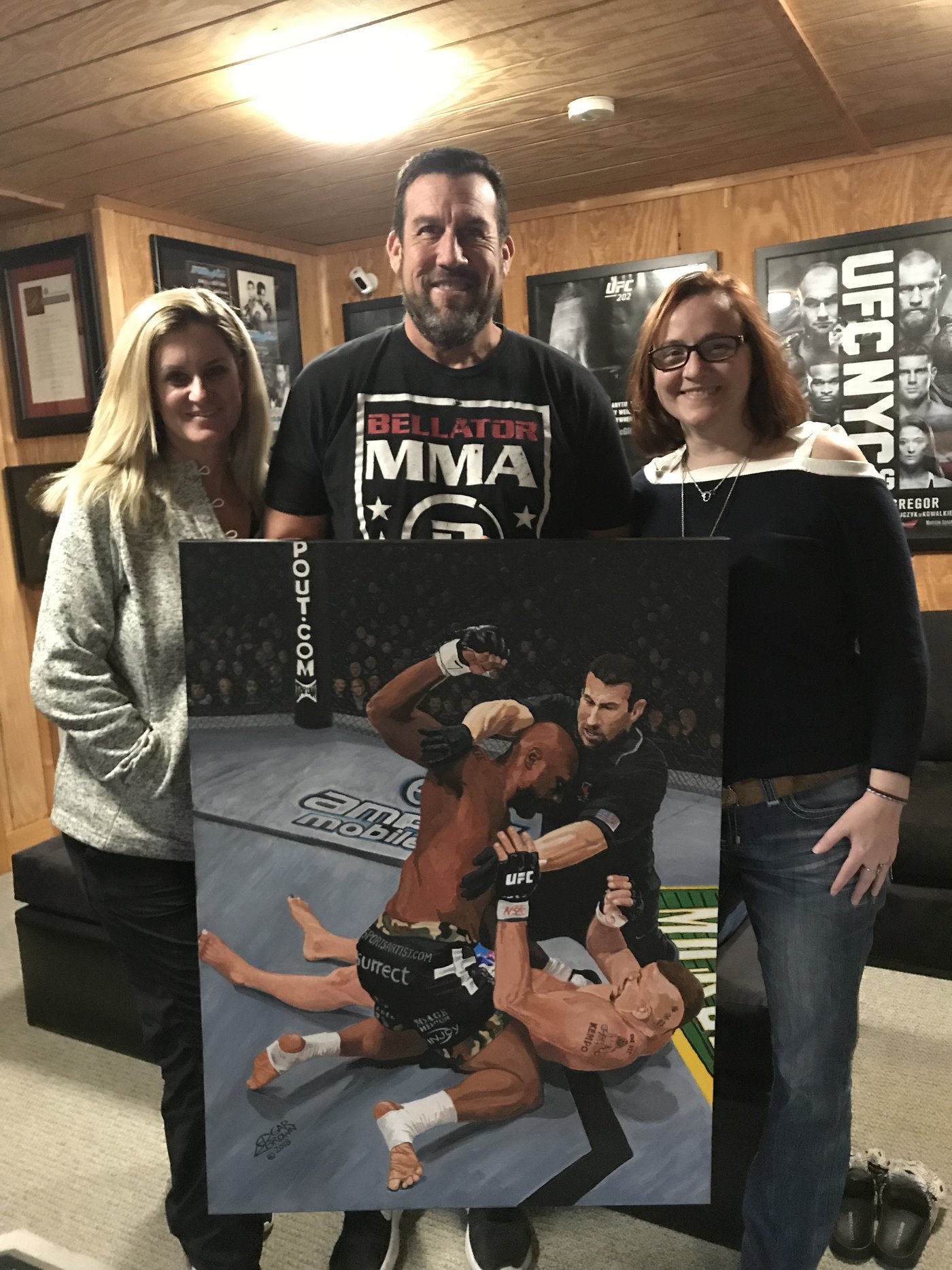 Elaine McCarthy, UFC referee Big John McCarthy and journalist Loretta Hunt at home with the finished 30x40 acrylic painting of the UFC 71 Liddell-Jackson fight, painted by Edgar J. Brown
